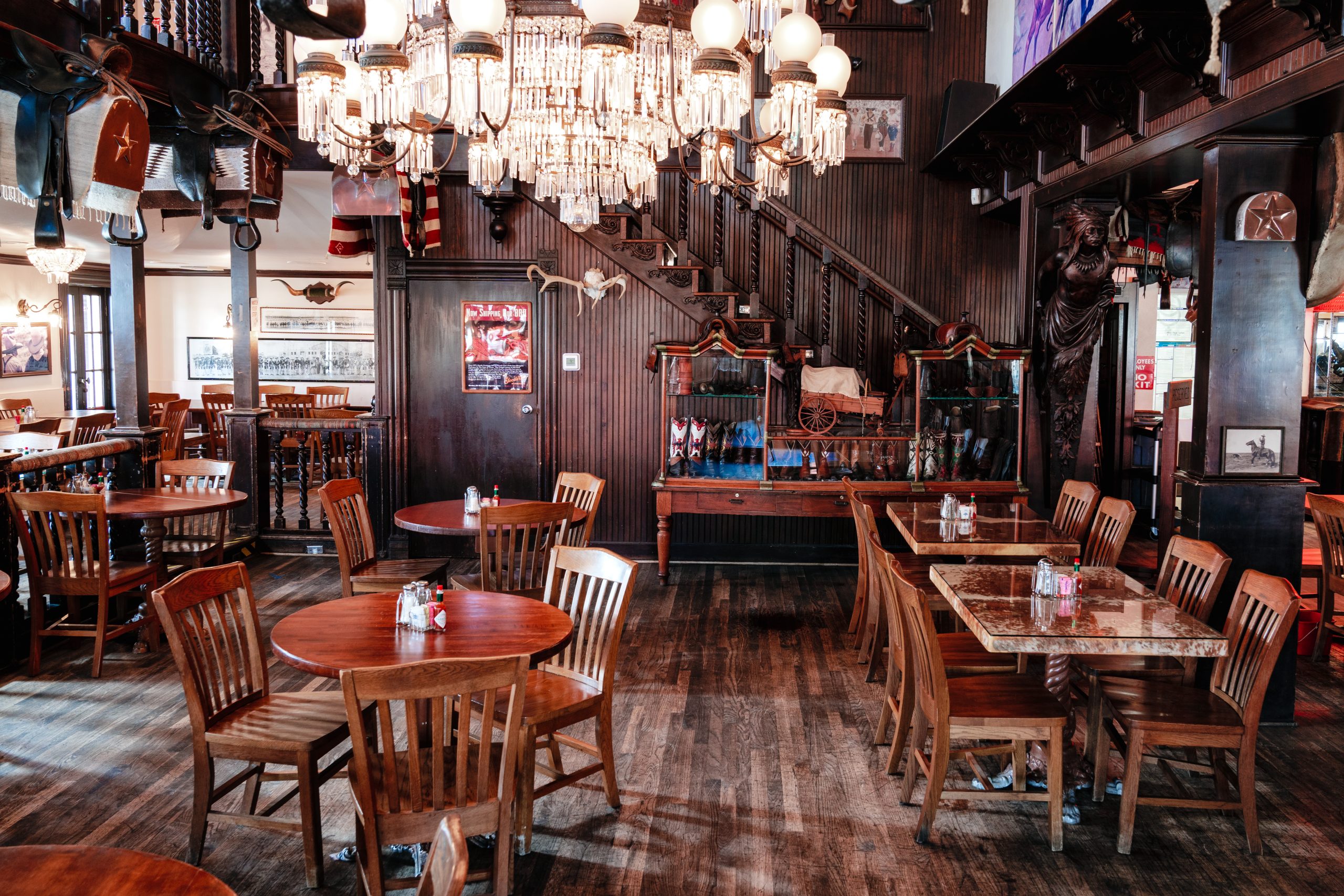 Tables and chairs, chandelier, and display case of Goode Co. restaurant